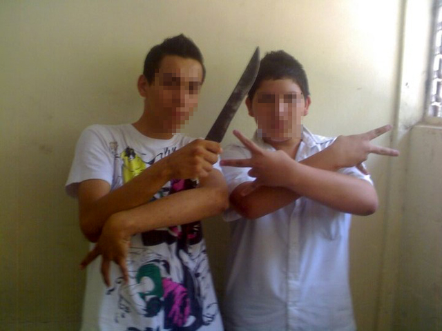 En Facebook, aquellos estudiantes que simpatizan con las razas dan a conocer sus simpatías. En la foto, dos jóvenes posan con un machete en un aula del Instituto Nacional de Comercio.