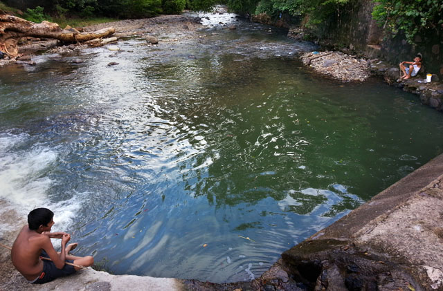 Dos niños pescan con cañas improvisadas en uno de los puntos ciegos de San Antonio Pajonal, donde el río Cusmapa hace de frontera natural.